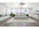 Spacious primary bedroom with bright windows, a seating area, and a luxurious king-sized bed at 7931 Campers Village Ave, Las Vegas, NV 89178