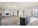 A kitchen with an island with a stone countertop is next to the living room with fireplace at 7931 Campers Village Ave, Las Vegas, NV 89178