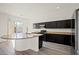 Modern kitchen with stainless steel appliances, granite countertops, dark cabinets, and a kitchen island at 7931 Campers Village Ave, Las Vegas, NV 89178
