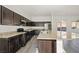 This kitchen features dark cabinets, stainless appliances, stone countertops, and a kitchen island at 7931 Campers Village Ave, Las Vegas, NV 89178