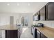 Modern kitchen featuring dark cabinets, stainless steel appliances, and granite countertops and opens to a sliding glass door at 7931 Campers Village Ave, Las Vegas, NV 89178