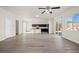 Spacious open-concept layout with wood-look flooring, a fan, and natural light flowing through sliding glass doors at 7931 Campers Village Ave, Las Vegas, NV 89178