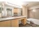 Bright bathroom featuring a vanity, a large mirror, and a shower-tub combination at 8000 Badura Ave # 1058, Las Vegas, NV 89113