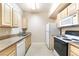 Functional kitchen with white appliances, wood cabinets, and tile flooring at 8000 Badura Ave # 1058, Las Vegas, NV 89113