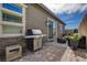 A cozy patio area with pavers, a grill, outdoor seating, and a view of the yard at 897 Woodburn Ln, Las Vegas, NV 89138