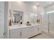 Bright bathroom featuring a double vanity with sleek cabinets and a glass-enclosed shower at 897 Woodburn Ln, Las Vegas, NV 89138