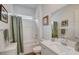 A modern bathroom with white fixtures, a shower and bathtub combo, and decor at 897 Woodburn Ln, Las Vegas, NV 89138