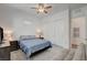 A well-lit bedroom with carpet, a ceiling fan, and access to the bathroom and walk-in closet at 897 Woodburn Ln, Las Vegas, NV 89138
