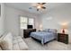 A bright bedroom with a ceiling fan, carpet, and two windows for natural light at 897 Woodburn Ln, Las Vegas, NV 89138