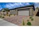 Single-story home featuring neutral color palette, stone accents, and paved driveway at 897 Woodburn Ln, Las Vegas, NV 89138