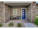 Front porch close up, featuring two chairs, a blue front door, and decorative stone pillars at 897 Woodburn Ln, Las Vegas, NV 89138