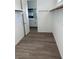 A walk-in closet with a view into the bathroom, hardwood flooring, and an installed clothes rod at 897 Woodburn Ln, Las Vegas, NV 89138