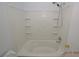 All white bathtub and shower combination with tiled walls at 9343 Leaping Deer Pl # 103, Las Vegas, NV 89178