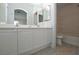Ensuite bathroom with double sinks, white cabinetry, and framed mirrors at 9343 Leaping Deer Pl # 103, Las Vegas, NV 89178