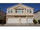 Beige two-story townhome featuring a multi-car garage and well-maintained landscaping at 9343 Leaping Deer Pl # 103, Las Vegas, NV 89178