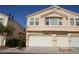 Beige two-story townhome featuring a multi-car garage and well-maintained landscaping at 9343 Leaping Deer Pl # 103, Las Vegas, NV 89178