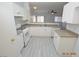 Bright kitchen features white cabinets, gas range, stainless steel dishwasher, and stone countertops at 9343 Leaping Deer Pl # 103, Las Vegas, NV 89178