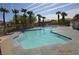Community pool surrounded by palm trees offers a resort-style living experience in a gated community at 9343 Leaping Deer Pl # 103, Las Vegas, NV 89178