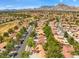 Expansive aerial view of a community nestled amongst lush landscaping, golf courses, and distant mountain views at 9540 Eagle Valley Dr, Las Vegas, NV 89134