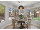 Cozy dining area featuring large windows, decorative lighting, and seating for four guests at 9540 Eagle Valley Dr, Las Vegas, NV 89134