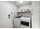 Convenient laundry room with modern washer and dryer, white cabinets, and neutral walls, blending style and functionality at 9540 Eagle Valley Dr, Las Vegas, NV 89134