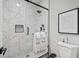 Modern shower featuring marble tile, black trim, and decorative niches for bathroom accessories and toiletries at 9540 Eagle Valley Dr, Las Vegas, NV 89134