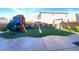 Fully landscaped backyard features a playground, swing set, synthetic grass and pavers at 10152 Tenaya Meadows St, Las Vegas, NV 89178
