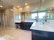 Bathroom with double sinks, tiled floors, large mirrors, and dark cabinets with white countertops at 10152 Tenaya Meadows St, Las Vegas, NV 89178