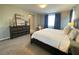 Well lit bedroom features a large bed, dark wood furniture, and a cozy reading chair at 10152 Tenaya Meadows St, Las Vegas, NV 89178