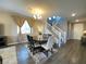 Dining room features a modern chandelier, seating for six, and a staircase at 10152 Tenaya Meadows St, Las Vegas, NV 89178