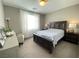Carpeted main bedroom with a white sofa-chair, lamps, and a dark wood bed and furniture at 10152 Tenaya Meadows St, Las Vegas, NV 89178