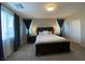 This is a carpeted main bedroom with natural light coming in and dark colored furniture at 10152 Tenaya Meadows St, Las Vegas, NV 89178