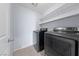 Well-lit laundry room with modern, stainless steel washer and dryer and storage shelves at 10373 Northern Hills Ave, Las Vegas, NV 89166
