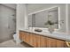 Modern bathroom featuring a floating wood vanity, an LED mirror, and a sleek glass shower at 10528 Garden Light Dr, Las Vegas, NV 89135