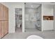 Bright bathroom with a glass shower, adjacent walk-in closet, and modern cabinetry at 10528 Garden Light Dr, Las Vegas, NV 89135