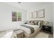 Bedroom features a large window, modern art, and coordinated bedside lamps and decor at 10528 Garden Light Dr, Las Vegas, NV 89135