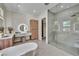 Modern main bathroom with floating vanities, a glass enclosed shower, and a soaking tub at 10528 Garden Light Dr, Las Vegas, NV 89135