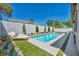 Private backyard oasis featuring a modern pool, spa, and lush landscaping, perfect for relaxation and entertainment at 10528 Garden Light Dr, Las Vegas, NV 89135