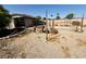 A view of the fenced-in backyard with a storage shed and a view of the sandy landscape at 10561 Rancho Destino Rd, Las Vegas, NV 89183