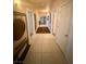 A brightly lit hallway with tile floors and several doorways at 10561 Rancho Destino Rd, Las Vegas, NV 89183