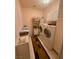 A well lit laundry room with tile floors, overhead cabinets, a folding table, and laundry machines at 10561 Rancho Destino Rd, Las Vegas, NV 89183