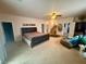 This spacious main bedroom features neutral carpeting, a ceiling fan, and a door to the main bathroom at 10561 Rancho Destino Rd, Las Vegas, NV 89183
