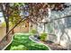 Landscaped backyard with artificial turf, rock features, mature trees, and a well-maintained exterior of the home at 11833 Amistoso Ln, Las Vegas, NV 89138