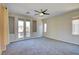 Spacious main bedroom with carpet, ceiling fan, and large glass patio doors to balcony at 11833 Amistoso Ln, Las Vegas, NV 89138