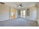 Spacious main bedroom with carpet, ceiling fan, and glass patio doors to balcony at 11833 Amistoso Ln, Las Vegas, NV 89138