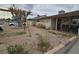A single-story home with an unkempt front yard with a swing set and rock facade at 1338 Smoke Tree Ave, Las Vegas, NV 89108