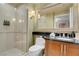 Well-lit bathroom featuring a glass shower, modern vanity, and decorative mirror at 135 E Harmon Ave # 3620, Las Vegas, NV 89109