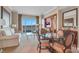 Cozy living space with a view of the cityscape, sofa, chair, and cabinet with a modern television at 135 E Harmon Ave # 3620, Las Vegas, NV 89109
