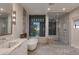 A modern bathroom featuring marble accents, a soaking tub, a glass shower, and sunset views at 1491 Reims Dr, Henderson, NV 89012