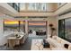 A spacious living room with floor-to-ceiling windows offering stunning sunset views, featuring modern decor and an open floor plan at 1491 Reims Dr, Henderson, NV 89012